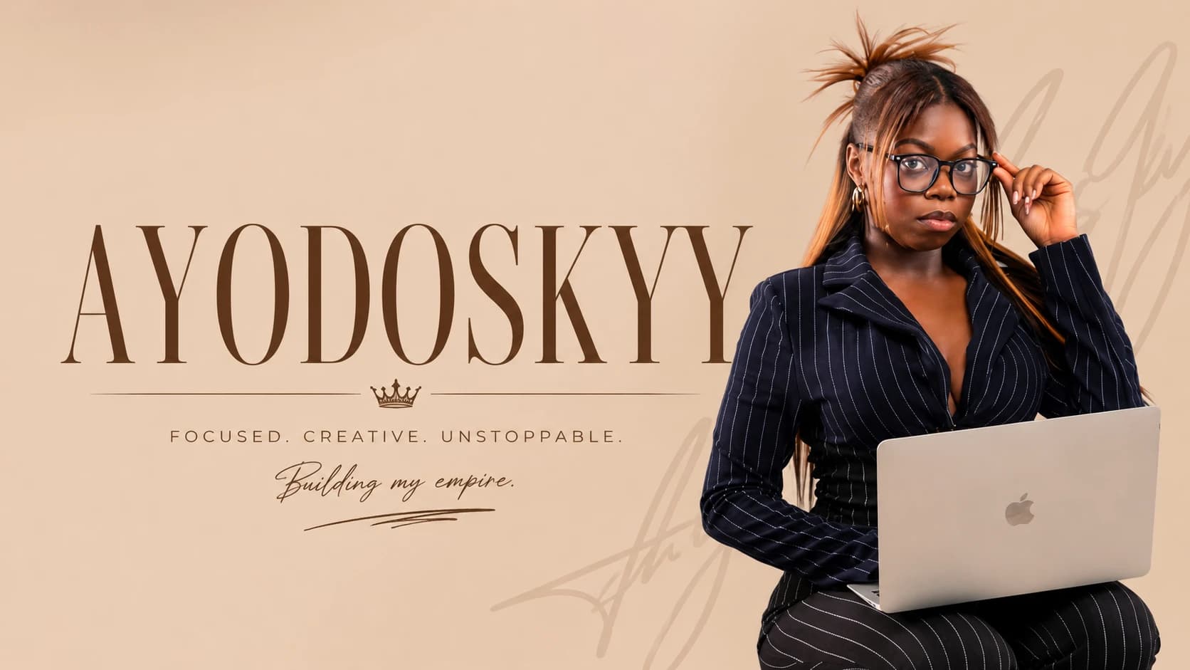Precious in a pinstripe suit with a laptop, beside the Ayodoskyy wordmark and "Focused. Creative. Unstoppable. Building my empire."